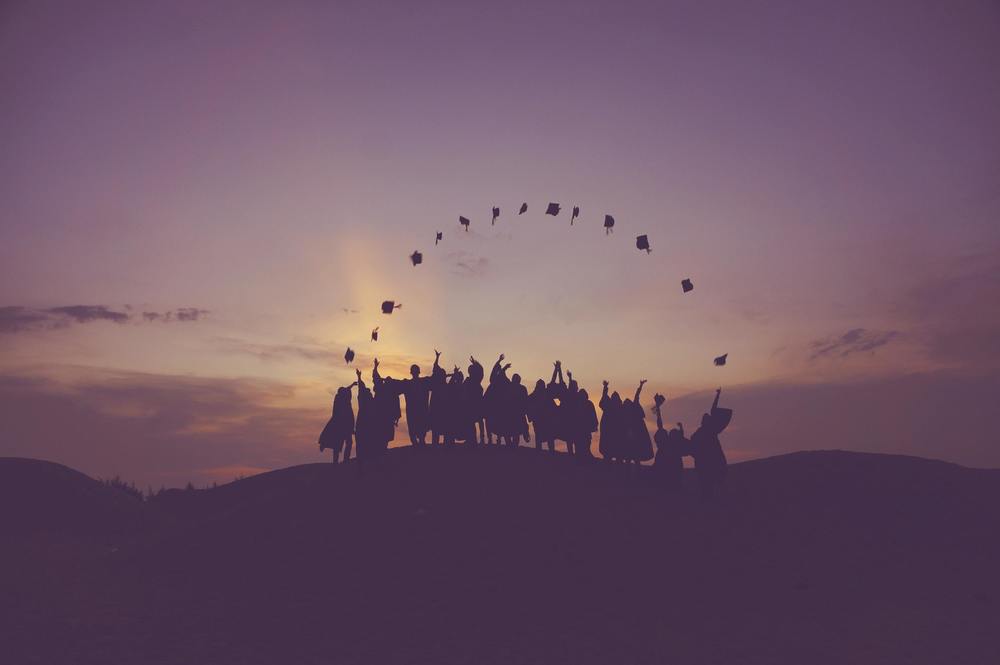 Silhouette of high school graduates throwing caps