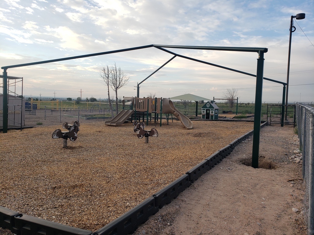 Early Childhood playground with shades under construction, pony spring riders, play structure, and playhouse.